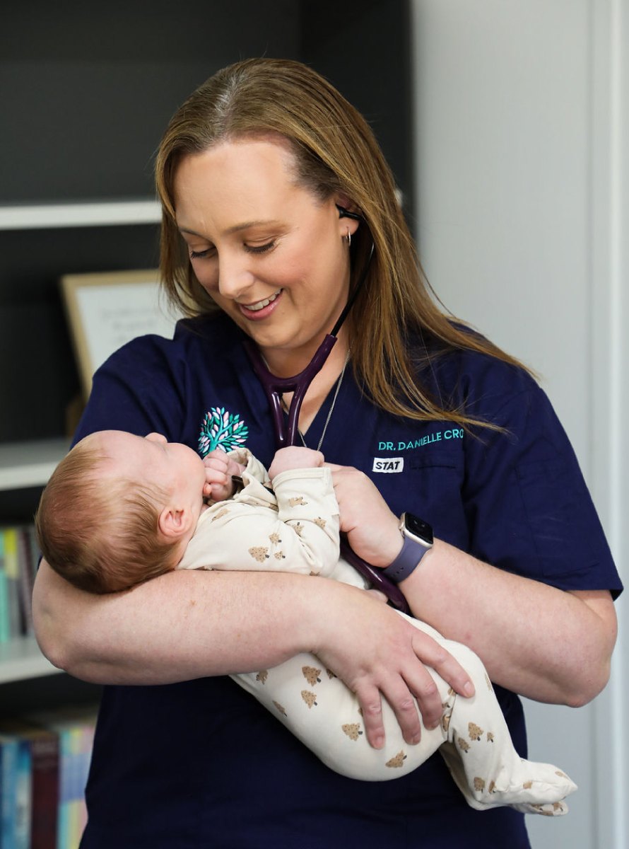 Dr Crosby cradles a sleeping newborn
