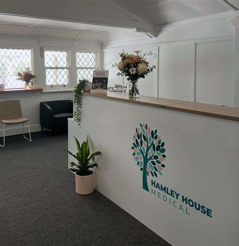 The reception desk at Hamley House, with the tree logo on its front